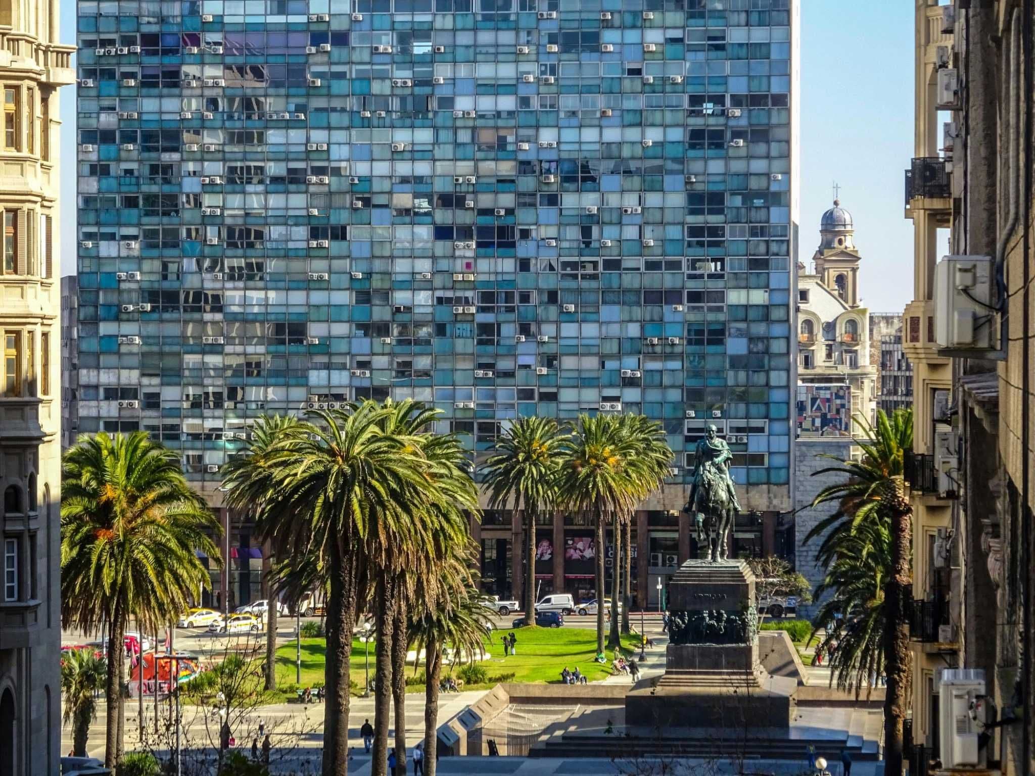 View of Montevideo city center with palm trees and modern buildings, highlighting Uruguay’s stable real estate market