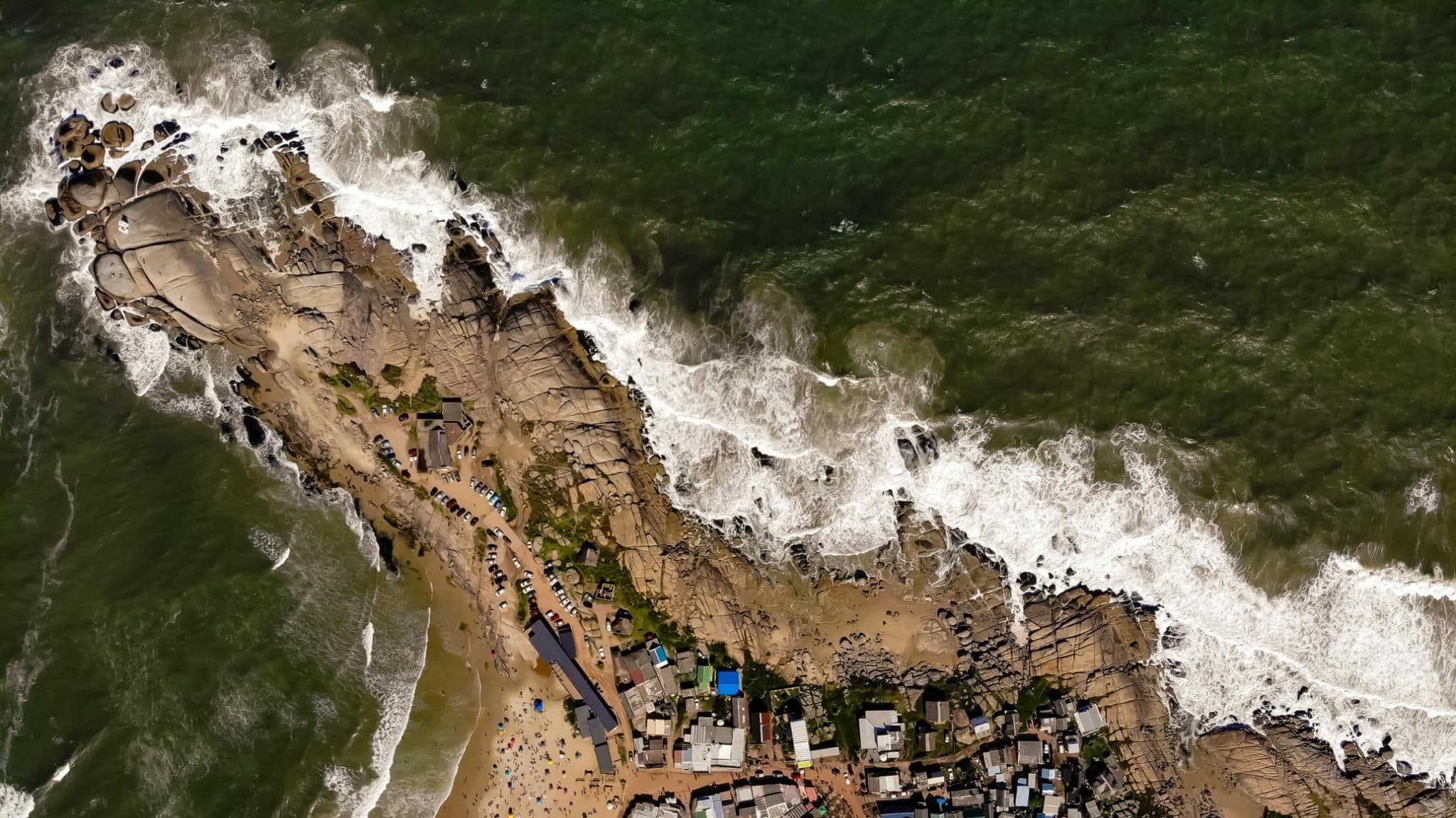 Aerial view of Uruguay coastline with homes and beach, illustrating real estate activity and property demand